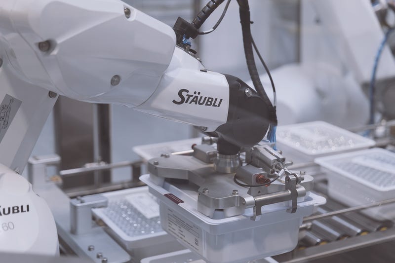 Another Stäubli robot seals the trays with a lid and applies two labels.